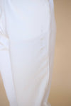 Closeup of the embroidered 'viens avec moi' detail on the side seam of the lightweight white jogger pants.