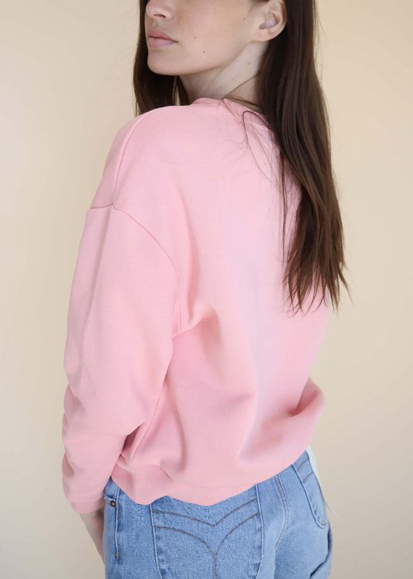 Drop sleeve detail and back view of the pink crewneck sweater made from eco-conscious fabric.