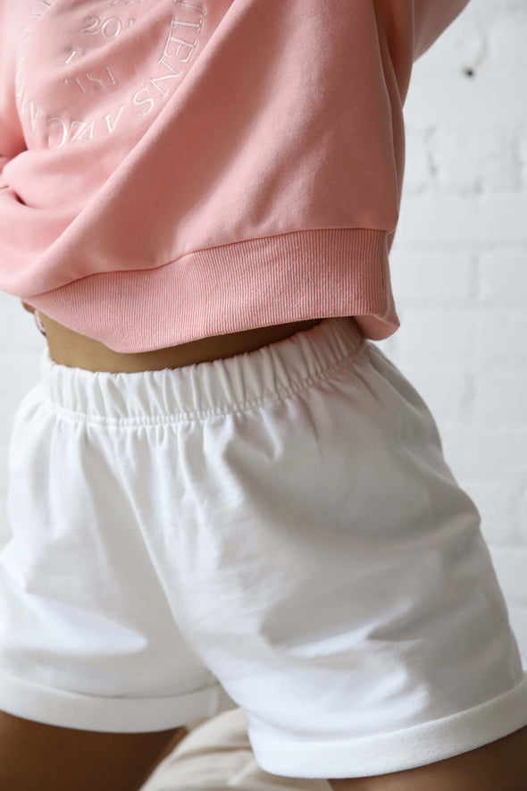 Closeup of the bottom hem on the boxy fit, crewneck pink sweater made by Viens Avec Moi from eco-conscious fabrics.