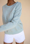 The Lakeside Crew in Seafoam is a light green sweater with a front embroidered design and cute dropped shoulder details in a cropped length.