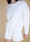 Cozy white crewneck sweater with subtle logo design, dropped shoulder details and relaxed fit.