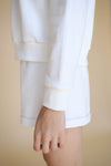 Closeup of the sleeve details on the white crewneck sweater by Viens Avec Moi, an Ottawa, Canada boutique.