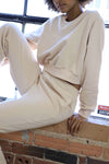 Closeup of the neutral loungewear set with cropped crewneck sweater and embroidered front design.