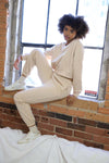 Nude loungewear set featuring a cropped crewneck sweater with embroidered front design and a fleece lining.