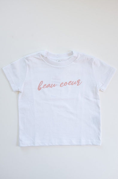 Viens Avec Moi Beau Coeur Tee for Kids designed for the Heart Institute. White cotton tee with a pink scripted print. Feminine and heartwarming.